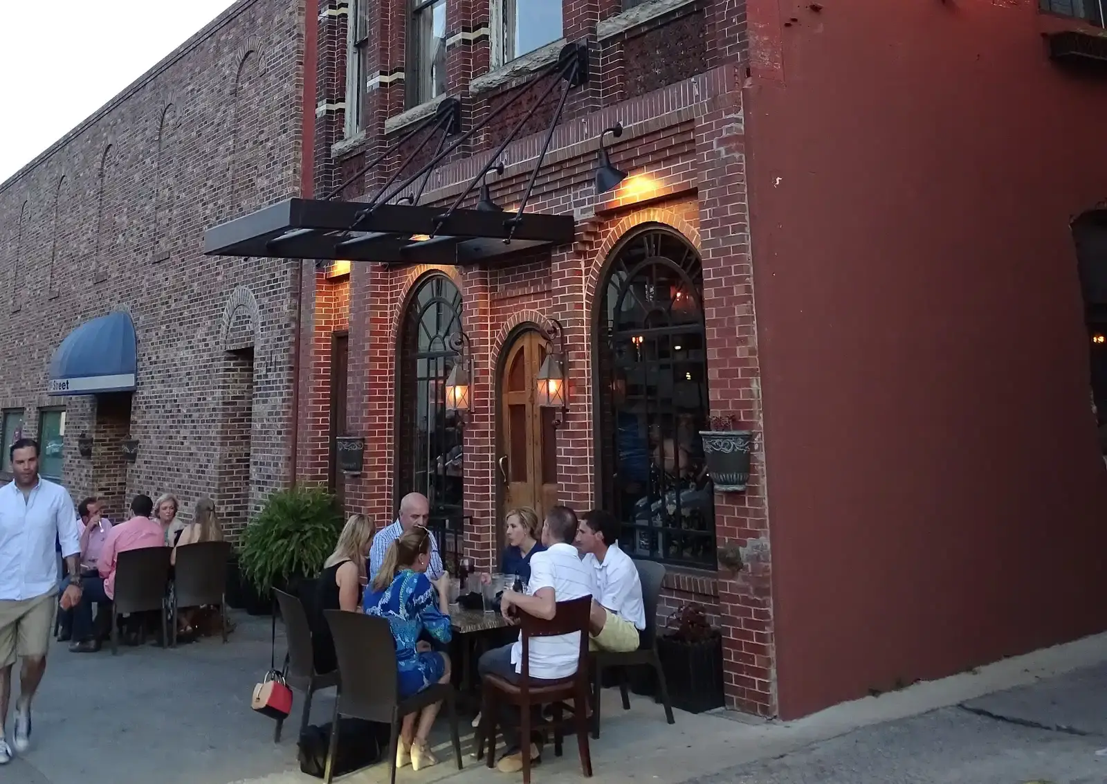 Outdoor dining at dusk outside a brick storefront in Columbus.